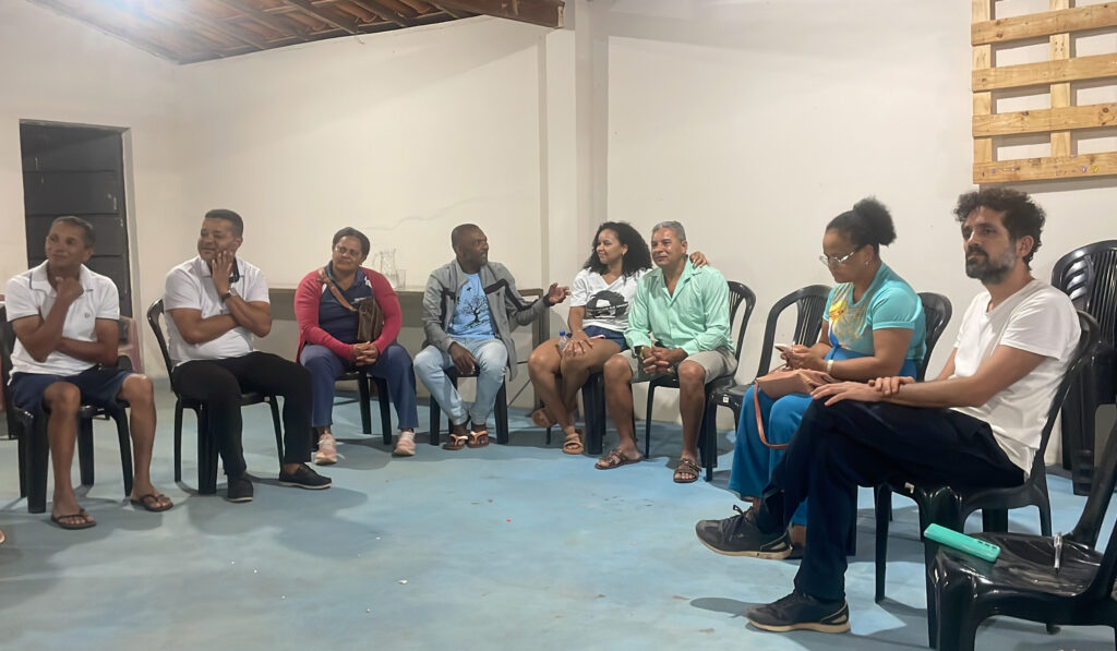 Vemos 8 pessoas sentadas que fazem parte de uma roda de conversa